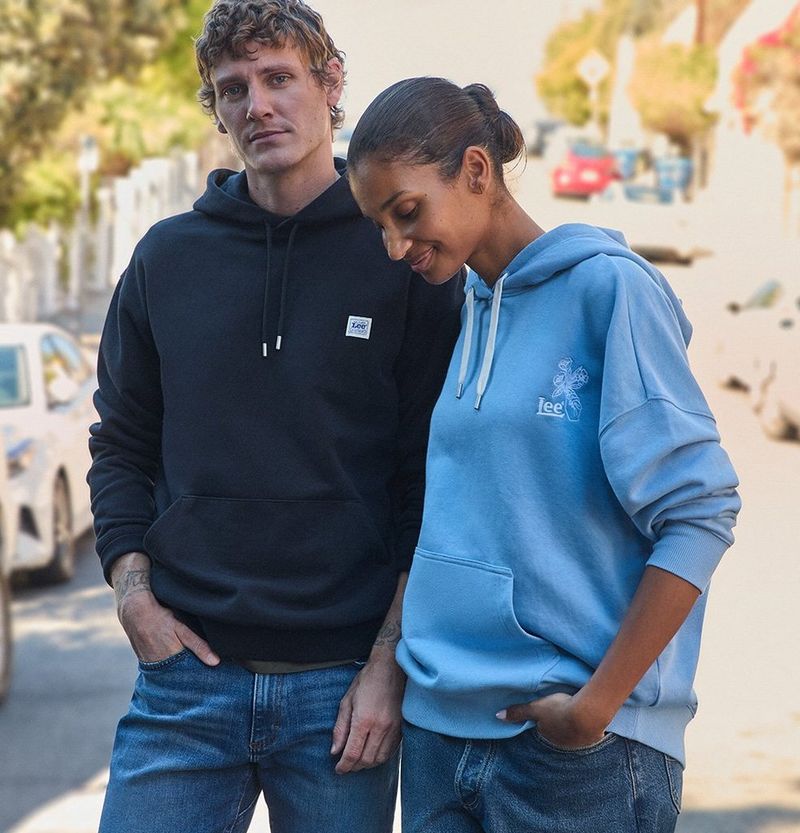 Couple outside in spring on city street wearing Lee clothing in layers.