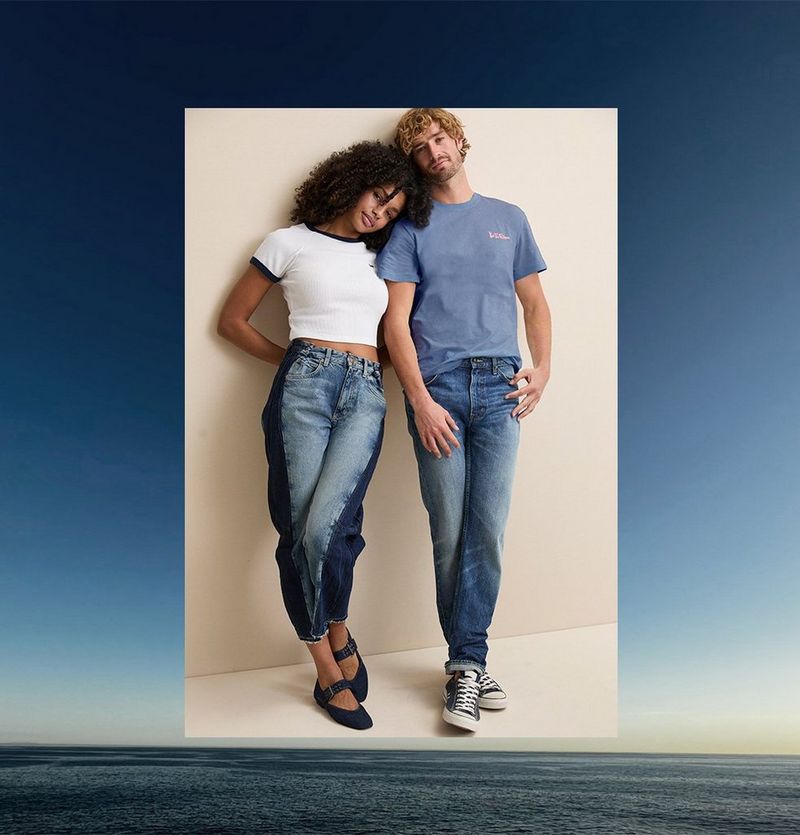 Couple leaning on a wall wearing Lee Jeans and tee shirts.