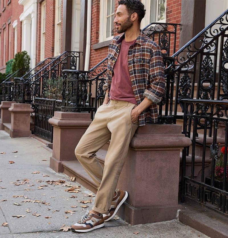 Man leaning on a city stoop wearing casual pants from Lee.