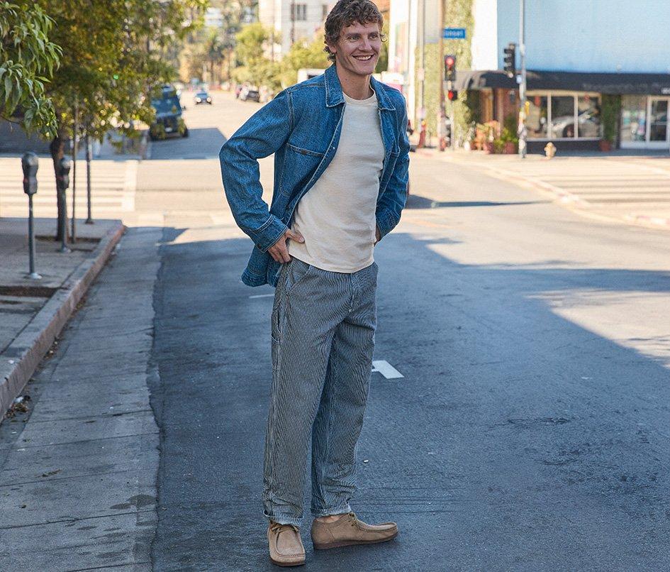 Man in city street wearing Lee Rail Road stripe carpenter jean.