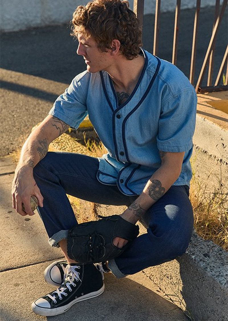 Man sitting on curb in the city wearing Lee 101