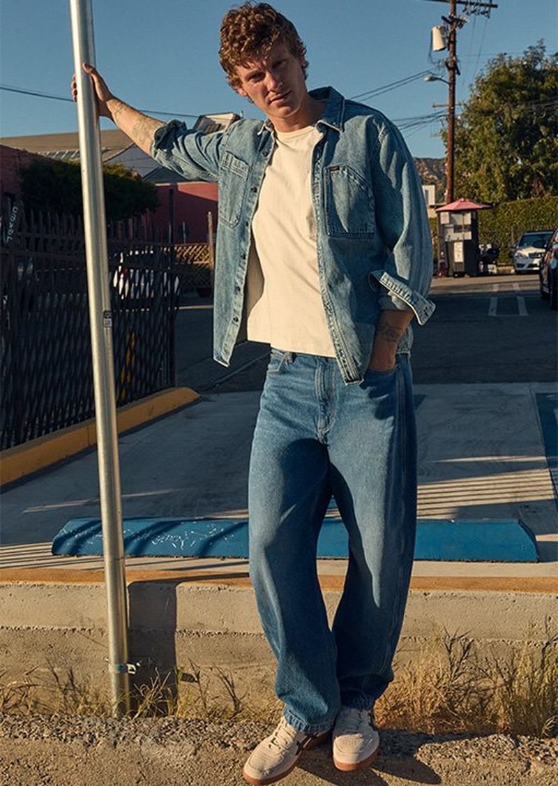 Man standing on street corner wearing Lee cotton Denim.